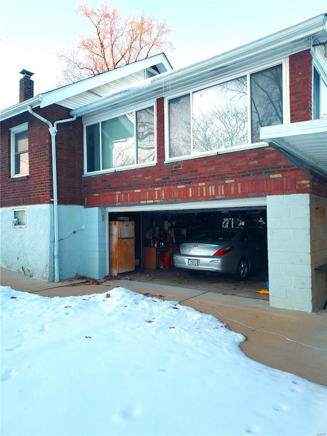 2106 Lackland Rd, Saint Louis, MO 63114 - view of front of property featuring a chimney, an attached garage, and brick siding