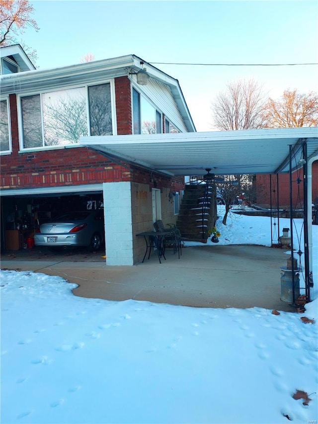 2106 Lackland Rd, Saint Louis, MO 63114 - view of snowy exterior featuring an attached garage and driveway