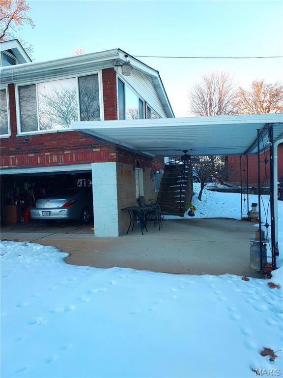 2106 Lackland Rd, Saint Louis, MO 63114 - snow covered property featuring a garage and driveway