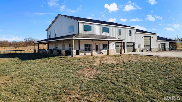 284 Ridge Rd, Oak Ridge, MO 63769 - view of front of home featuring a trampoline, concrete driveway, a front yard, stone siding, and an attached garage