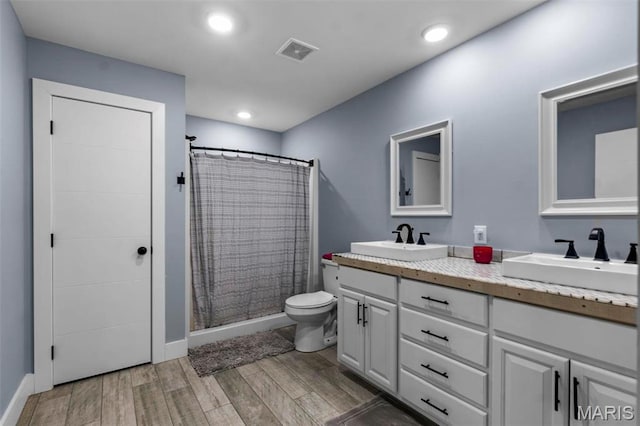 284 Ridge Rd, Oak Ridge, MO 63769 - bathroom featuring double vanity, toilet, a shower with shower curtain, wood finished floors, and baseboards