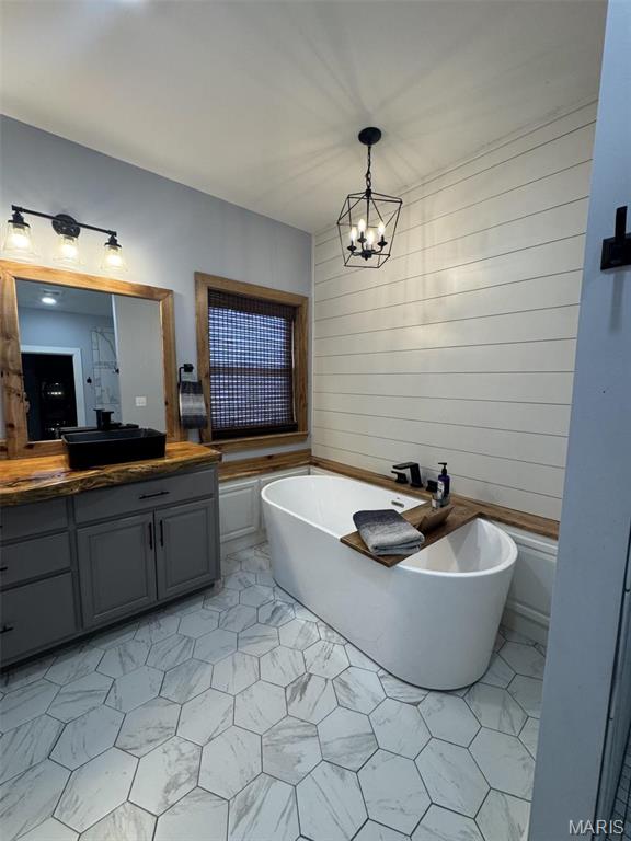 284 Ridge Rd, Oak Ridge, MO 63769 - bathroom featuring vanity, a freestanding bath, a chandelier, and wooden walls