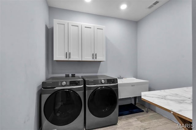 284 Ridge Rd, Oak Ridge, MO 63769 - washroom featuring cabinet space, washing machine and clothes dryer, light wood-style floors, and recessed lighting
