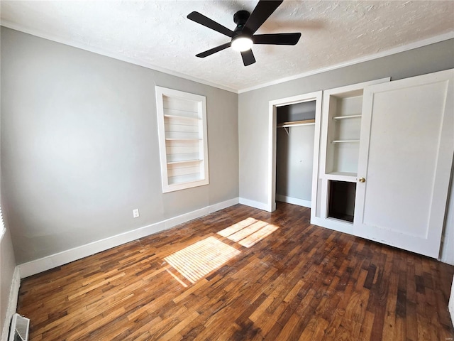 unfurnished bedroom featuring a textured ceiling, wood finished floors, baseboards, a closet, and crown molding