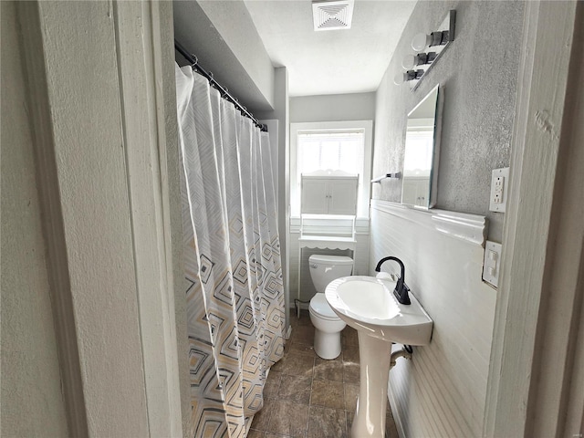 full bath with toilet and a sink