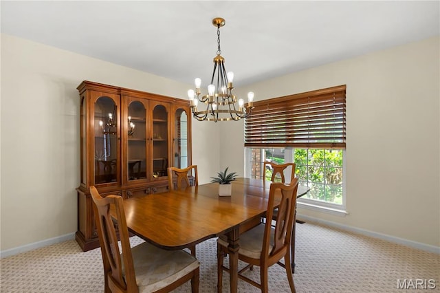 dining area with a chandelier, light carpet, and baseboards