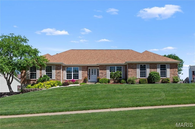 single story home with brick siding, a front lawn, and roof with shingles