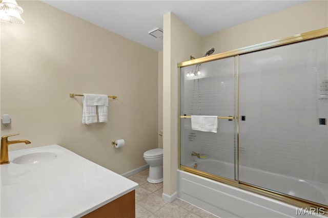 full bath featuring tile patterned floors, toilet, vanity, baseboards, and shower / bath combination with glass door