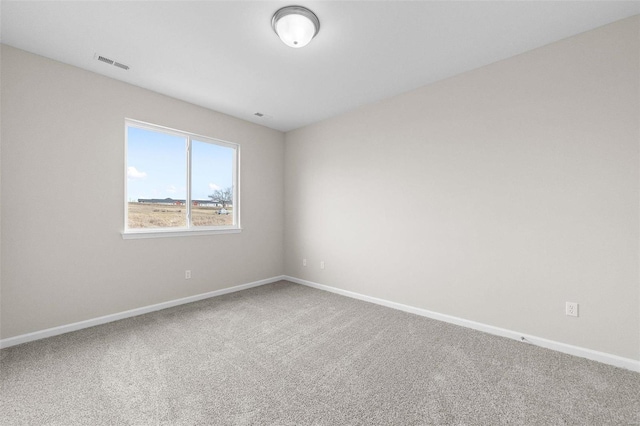 empty room featuring carpet and baseboards