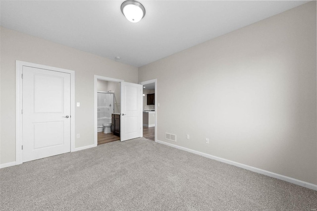 unfurnished bedroom featuring carpet, baseboards, and connected bathroom