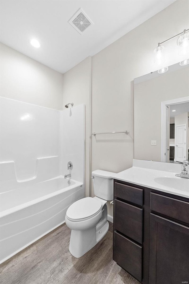 full bathroom featuring wood finished floors, vanity, toilet, and shower / tub combination