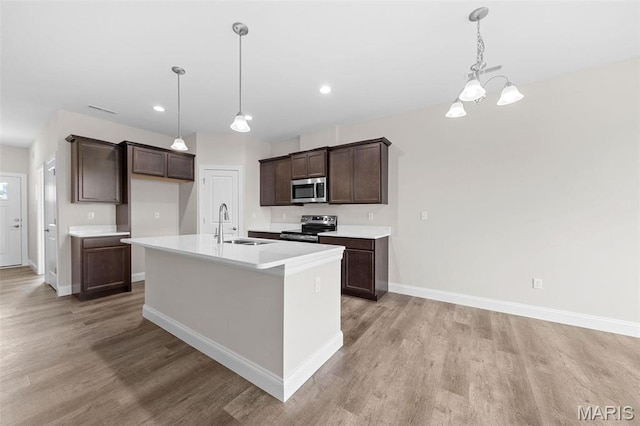 887 Walter Way, Washington, MO 63090 - kitchen featuring appliances with stainless steel finishes, light wood-style flooring, a sink, baseboards, and dark brown cabinetry