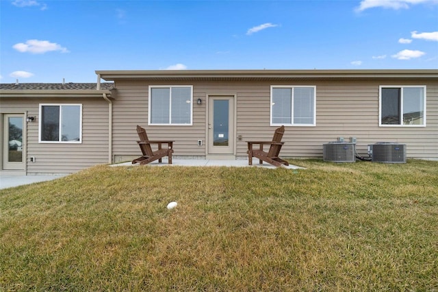 rear view of property with cooling unit, a patio area, and a yard