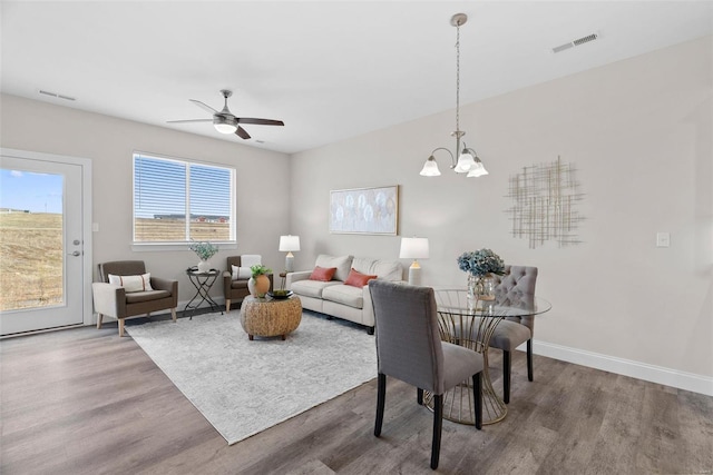 living area featuring wood finished floors, a chandelier, baseboards, and ceiling fan