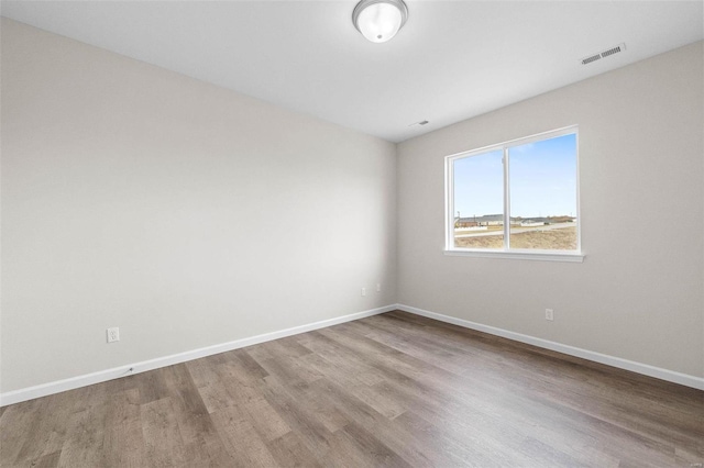 unfurnished room featuring wood finished floors and baseboards