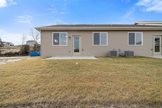 rear view of house featuring central AC unit, a lawn, and a patio area
