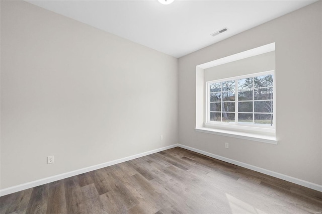 spare room featuring wood finished floors and baseboards