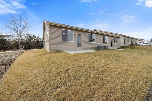 rear view of property with a lawn, a patio area, and central AC unit