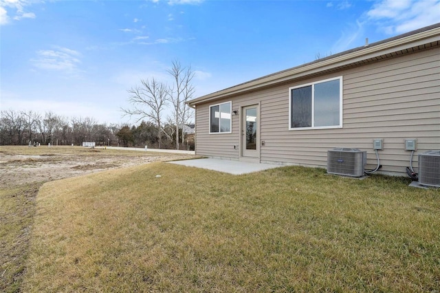 rear view of property with central AC and a yard