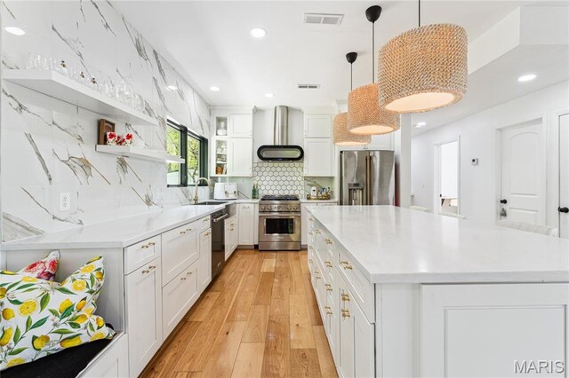 2510 N 89th St, Caseyville, IL 62232 - kitchen with stainless steel appliances, wall chimney range hood, open shelves, white cabinets, and light wood finished floors