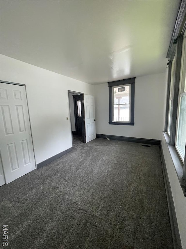 4947 Rosalie St, Saint Louis, MO 63115 - empty room with dark carpet and baseboards