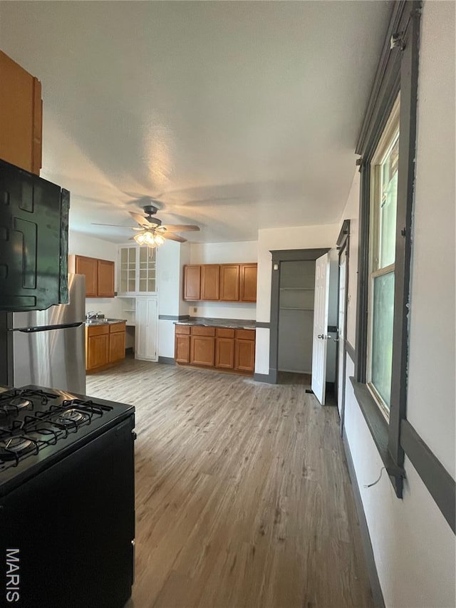 4947 Rosalie St, Saint Louis, MO 63115 - kitchen with black appliances, brown cabinets, a ceiling fan, and plenty of natural light