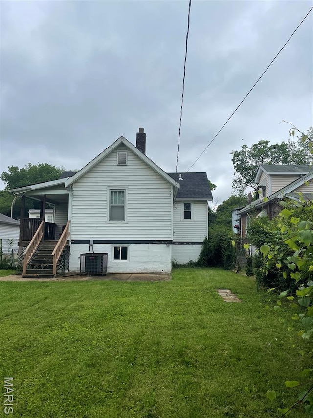 4947 Rosalie St, Saint Louis, MO 63115 - rear view of property with a chimney, central AC, a yard, and stairs