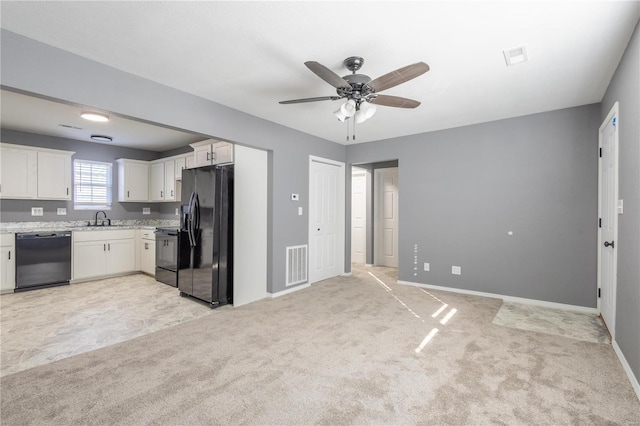 2347 Arkansas Ave, Poplar Bluff, MO 63901 - kitchen with black appliances, ceiling fan, light colored carpet, and white cabinetry