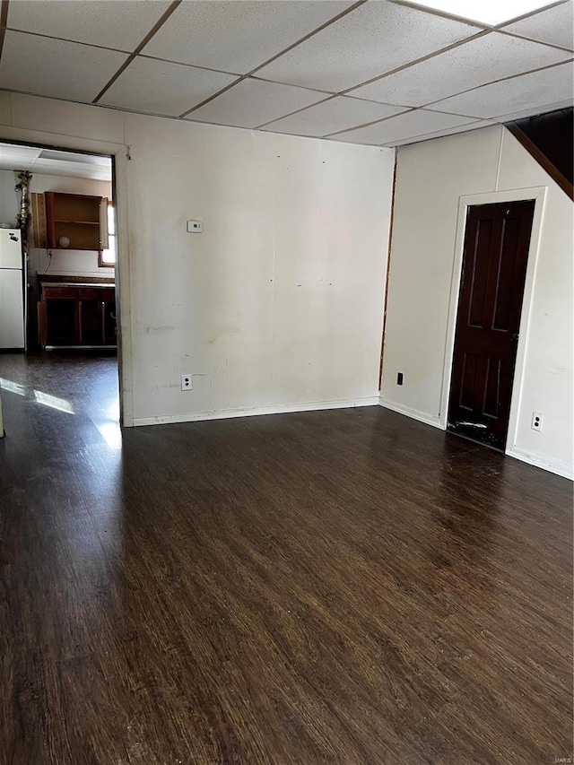 1642 3rd St, Madison, IL 62060 - empty room with wood finished floors, a paneled ceiling, and baseboards