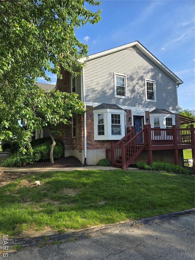 1619 Florine Boulevard E, Saint Charles, MO 63303 - view of front facade featuring brick siding, a wooden deck, a front yard, and a chimney