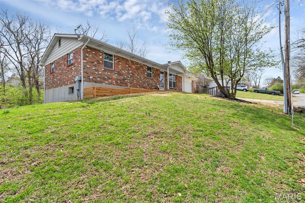 156 Hinrichs Ln, Arnold, MO 63010 - back of house with brick siding, an attached garage, and a yard