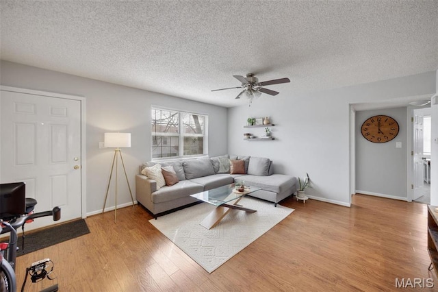1419 Bluebird Ter, Saint Louis, MO 63144 - living area featuring ceiling fan, light wood-style flooring, a textured ceiling, and baseboards