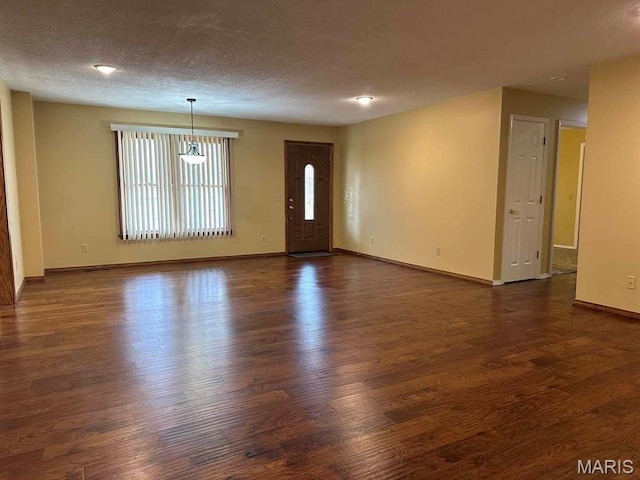 17264 Cedar Hills Dr, Dexter, MO 63841 - unfurnished living room with dark wood-style flooring, baseboards, and a textured ceiling