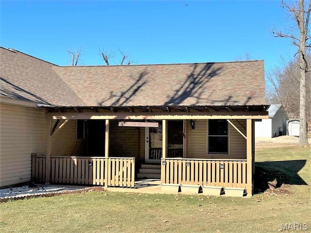17264 Cedar Hills Dr, Dexter, MO 63841 - back of house with a shingled roof, covered porch, and a lawn