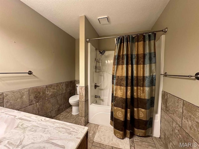 17264 Cedar Hills Dr, Dexter, MO 63841 - full bathroom featuring tile walls, shower / tub combo, a textured ceiling, a wainscoted wall, and vanity