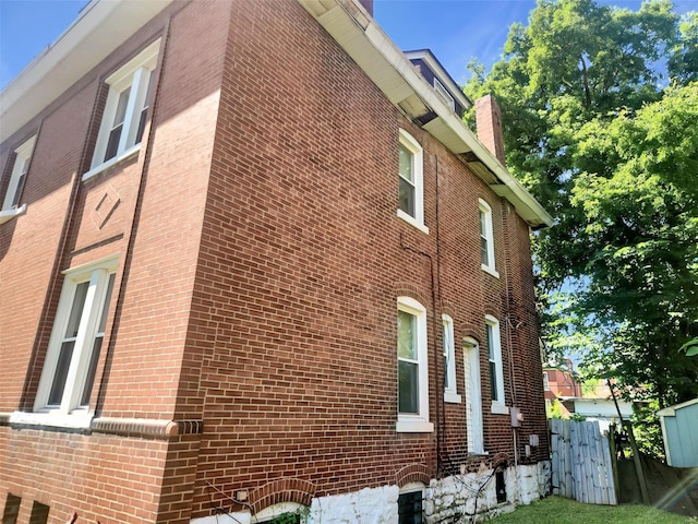 4918 Highland Ave, Saint Louis, MO 63113 - view of side of property featuring brick siding, a chimney, and fence