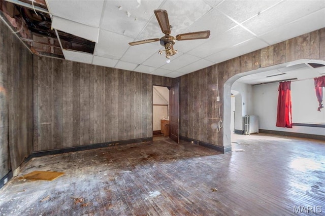 7307 Minnesota Ave, Saint Louis, MO 63111 - empty room with wood walls, arched walkways, a paneled ceiling, hardwood / wood-style flooring, and baseboards