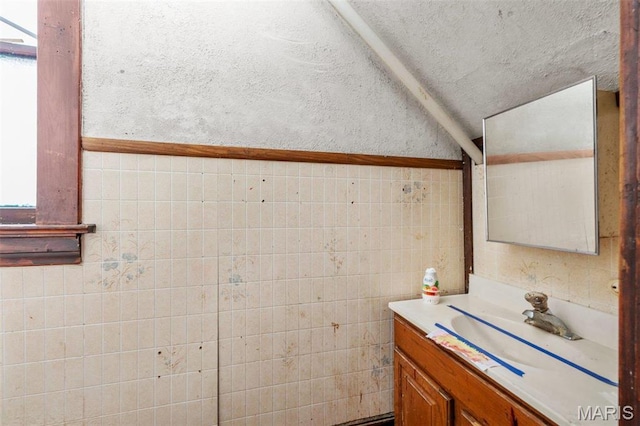 7307 Minnesota Ave, Saint Louis, MO 63111 - bathroom featuring vaulted ceiling, tile walls, and vanity