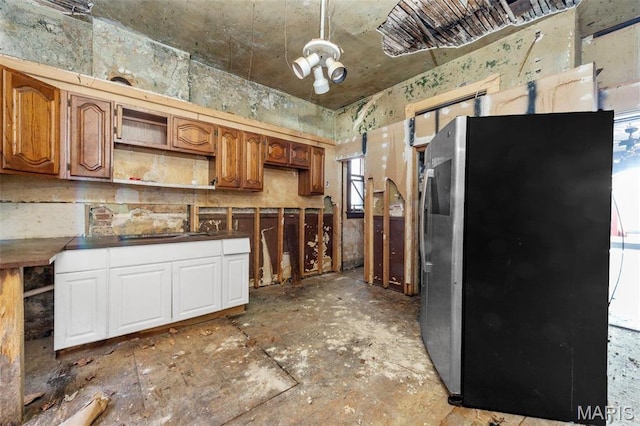 7307 Minnesota Ave, Saint Louis, MO 63111 - kitchen featuring freestanding refrigerator, open shelves, dark countertops, and brown cabinets