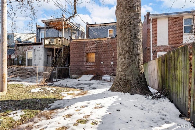 7307 Minnesota Ave, Saint Louis, MO 63111 - snow covered house featuring a fenced backyard, brick siding, and stairway