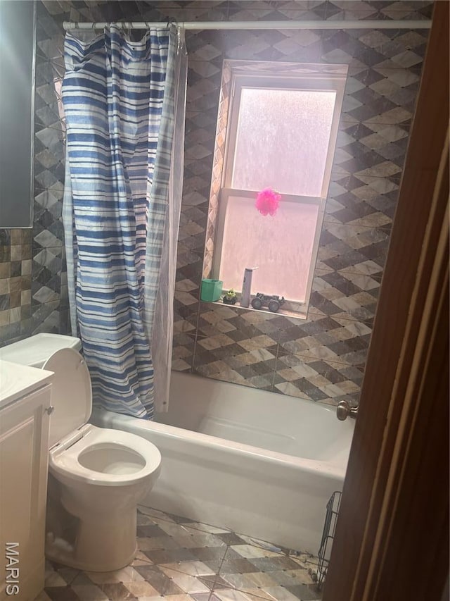4600 Carrie Ave, Saint Louis, MO 63115 - bathroom featuring shower / bath combo, vanity, tile walls, and toilet