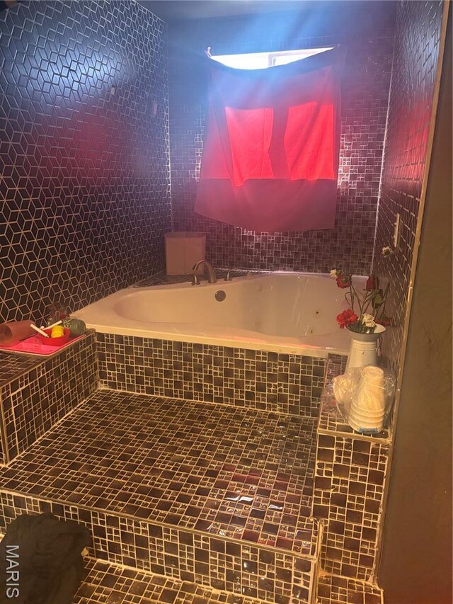 4600 Carrie Ave, Saint Louis, MO 63115 - bathroom featuring a jetted tub, tile walls, and tile patterned flooring