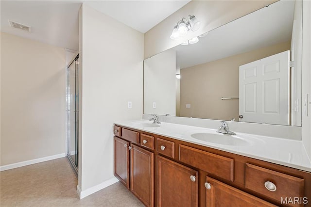 bathroom featuring a stall shower, double vanity, and baseboards