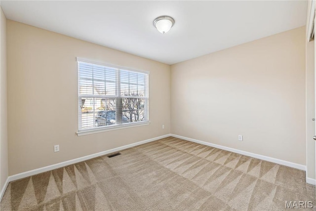 carpeted empty room featuring baseboards