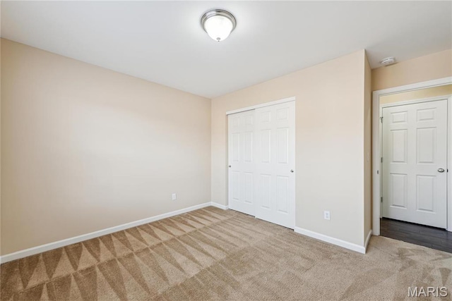 unfurnished bedroom with carpet, baseboards, and a closet