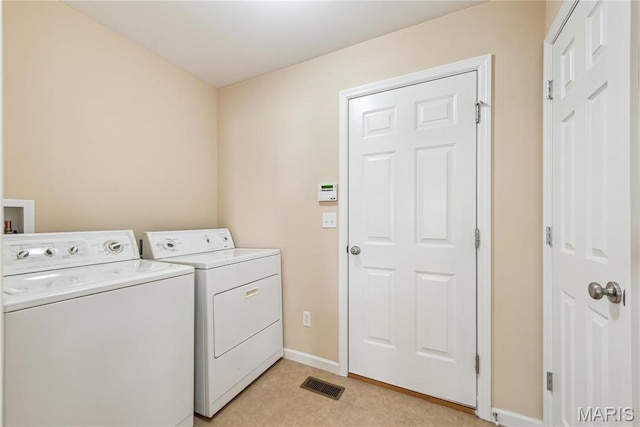 laundry area with washing machine and dryer and baseboards