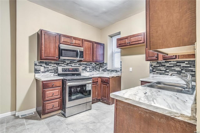3018 Texas Ave, Saint Louis, MO 63118 - kitchen featuring appliances with stainless steel finishes, a sink, light countertops, and decorative backsplash