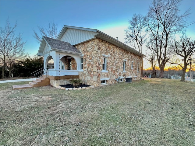 601 S Grand St, Salem, MO 65560 - property exterior at dusk with stone siding, a yard, and central AC