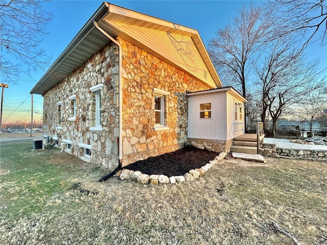 601 S Grand St, Salem, MO 65560 - view of property exterior featuring stone siding, central air condition unit, and a yard