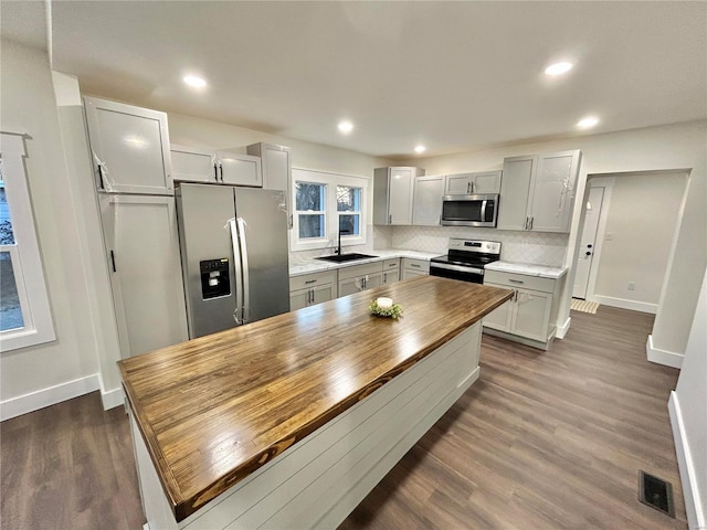 601 S Grand St, Salem, MO 65560 - kitchen featuring stainless steel appliances, dark wood-style flooring, baseboards, a sink, and backsplash
